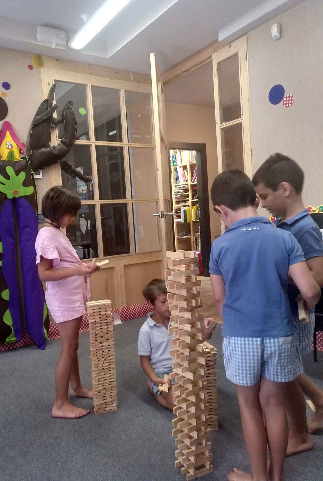 Varios niños juegan en Actitud Bilingüe haciendo unas torres en el campamento de inglés. 