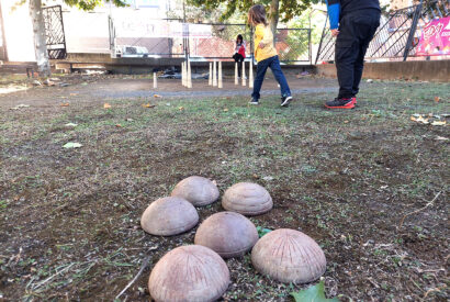 Un niño juega a los bolos leoneses en la bolera de la calle Cinco de Octubre de León