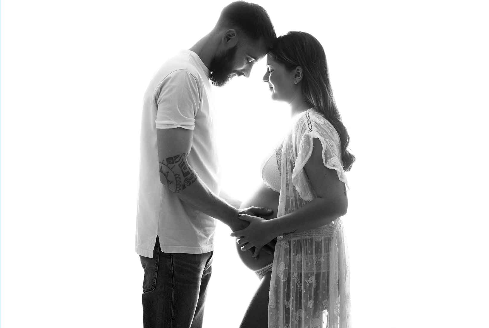 Fotografía de una mujer embarazada junto a su pareja en blanco y negro, de Jennifer Suárez Fotografía. 