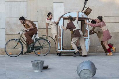 Un chico conduce una bicicleta que tira de un remolque con otras cuatro personas agarradas